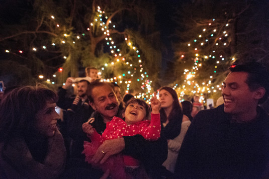 In the arms of her grandfather Joe Cota, Cota Hernandez, 3, looks up as Altadena's Christmas Tree Lane lights their deodar cedars for the 94th time on Saturday December 13, 2014.  Far left, is Cota's grandmother Laura Cota and father Peter Hernandez. It was the first time the family of Whittier witnessed the lighting. (Photo by Sarah Reingewirtz/Pasadena Star-News)