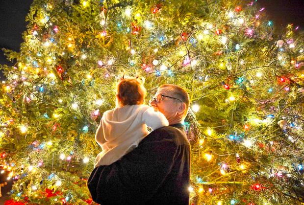 Ted Sorosky holds his fifteen month-old granddaughter McKayla Morrow for a better view of the Christmas lights on the 96-foot Christmas tree at South Coast Plaza during the annual tree lighting ceremony.

///ADDITIONAL INFORMATION:  11/21/2013-CHRISTINE COTTER,ORANGE COUNTY REGISTER - cu.southcoasttree.112513. South Coast Plaza will be holding their annual Christmas Tree lighting ceremony. The 96' tree, with over 20,000 lights, will be lit for the first time this season. Orange County High School of the Arts will be performing at the ceremony.