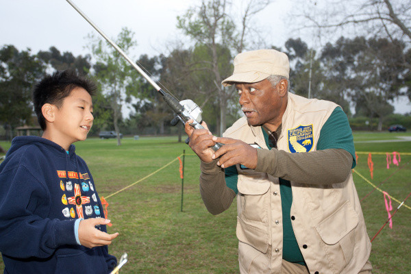 Timothy Rah gets some basic casting instruction from Department of Fish and Game's Willie Wagner during the 11th Annual Kids Fishing Derby at Mile Square Regional Park.  ///Additional Info: fv.fishingsnapshots.0321.wm.jpg --- Photo By WAYNE MAH FOR THE REGISTER -- 03/16/13 The 11th Annual Kids Fishing Derby was held Saturday, March 16, at Mile Square Regional Park. The lake was stocked with over 1500 pounds of trout specifically for the 627 kids registered for the event.