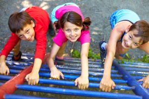 Three little children climbing ladder and looking at camera